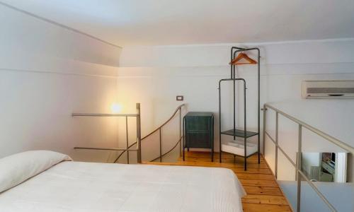 a white bedroom with a bed and a staircase at Cà Mì Apartment in Galatone