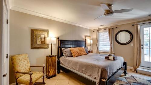 4 Bedroom Beauty Steps from the River في سافانا: غرفة نوم بسرير وكرسي ومروحة سقف