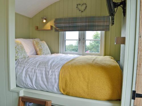 a bedroom with a bed and a window at The Wool Shed in Saint Ewe