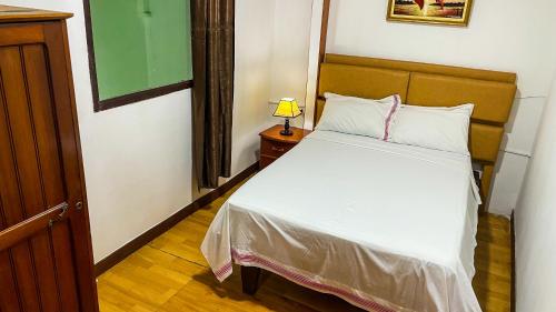 ein Schlafzimmer mit einem Bett und einer Lampe auf einem Tisch in der Unterkunft Apartamento El Roble in Iquitos