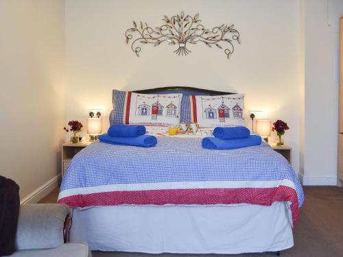 a bedroom with a bed with blue pillows on it at The Cabin in Pevensey