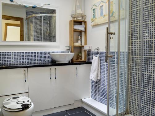 a bathroom with a sink and a shower at River Cottage in Llangunllo