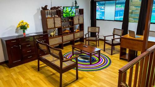 uma sala de estar com cadeiras, uma mesa e uma televisão em Apartamento El Roble em Iquitos