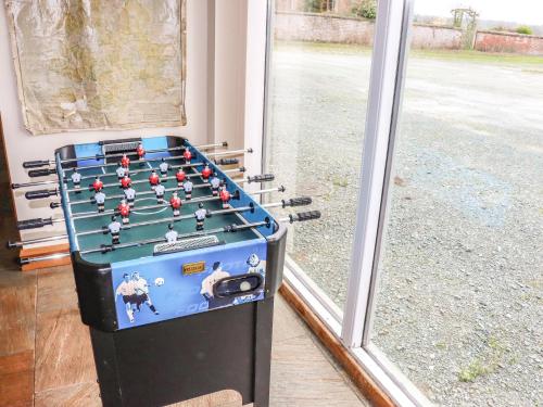 a foosball machine in front of a window at The Barn in Ellesmere