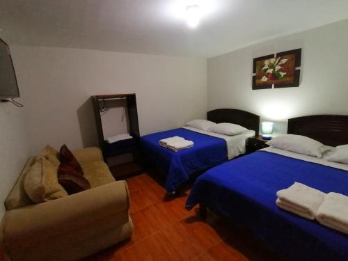 Habitación de hotel con 2 camas y sofá en hospedaje encantada en Cajamarca