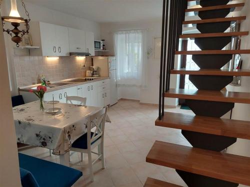 a kitchen with a table and chairs and a staircase at House Antonio in Miholascica (66-1) in Miholašćica