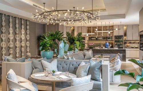 a restaurant with a blue couch and tables at Four Seasons Hotel Singapore in Singapore