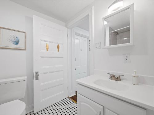 een witte badkamer met een wastafel en een spiegel bij Bloomfield/Shadyside @V Modern and Bright Private Bedroom with Shared Bathroom in Pittsburgh