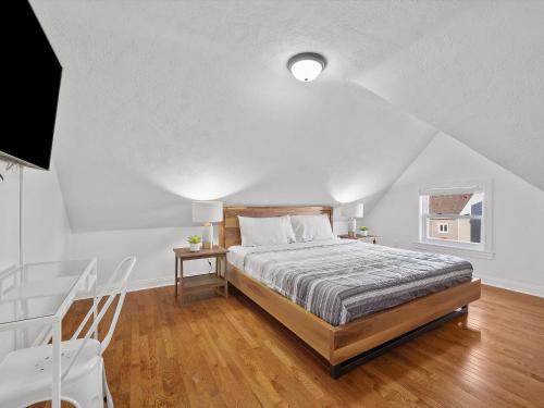 ein weißes Schlafzimmer mit einem Bett und einem Fenster in der Unterkunft Bloomfield/Shadyside @V Modern and Bright Private Bedroom with Shared Bathroom in Pittsburgh