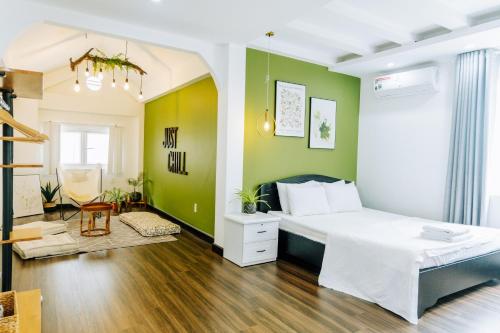 a bedroom with a white bed and green walls at Contemporary Greenhouse Garden Villa- 4 bedrooms Villa in Vung Tau