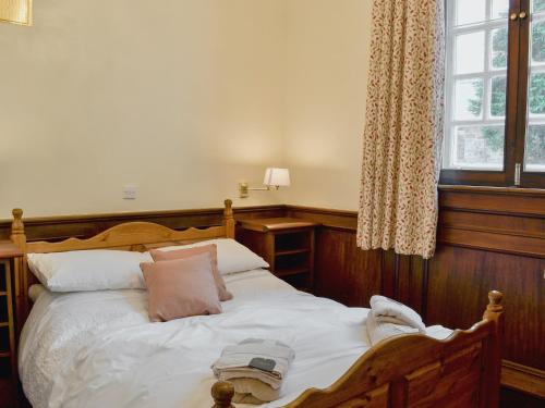 Trawsfynydd的住宿－Yr Hen Fanc，卧室配有带枕头的木床和窗户。