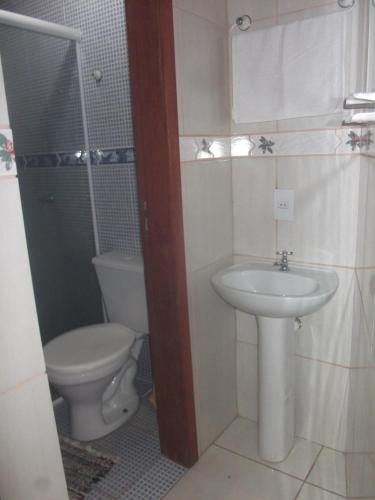 a bathroom with a toilet and a sink at Joaquina 433 - Pousada Floripa in Florianópolis