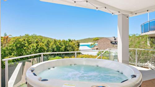 a bath tub on the balcony of a house at Coast Fingal Bay in Fingal Bay
