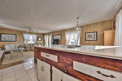 a kitchen with a counter and a living room at Fernandina Cottage Deck, Direct Beach Access in Fernandina Beach