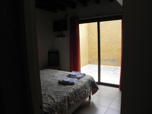 1 dormitorio con 1 cama con 2 toallas en Apartamiento acogedor y familiar cerca Del Río en Tunuyán