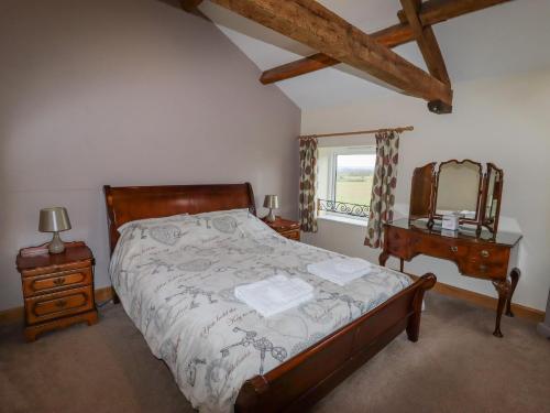 Schlafzimmer mit einem Bett, einer Kommode und einem Spiegel in der Unterkunft The Oaks in Ellesmere