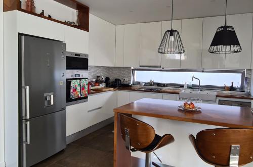 a kitchen with a stainless steel refrigerator and a wooden table at Magnolia Residence - central to explore the island in Ribeira Grande