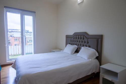 a bedroom with a white bed with a large window at ATW Apartments in Antwerp