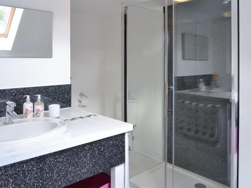 a white bathroom with a sink and a shower at Salty Dog in Findochty