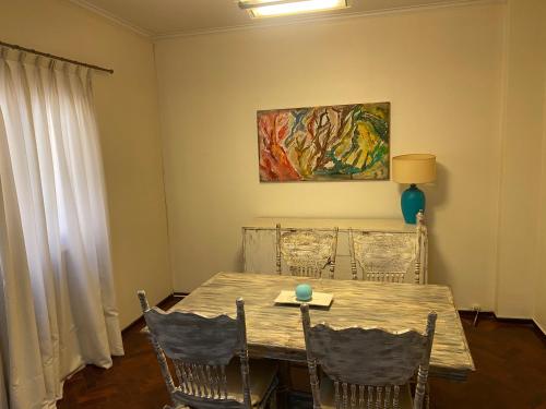 una mesa de comedor con sillas y una pintura en la pared en Departamento Av. España en Mendoza