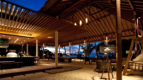 a pavilion with a table and chairs on the beach at Park Hyatt Maldives Hadahaa in Gaafu Alifu Atoll