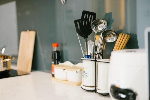 - un comptoir de cuisine avec des ustensiles dans un conteneur dans l'établissement Happy apartment, à Hanoï