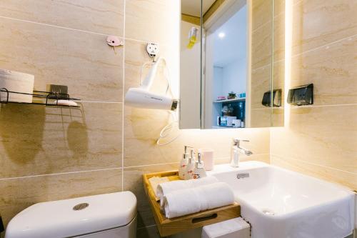 La salle de bains est pourvue d'un lavabo, de toilettes et d'un miroir. dans l'établissement Happy apartment, à Hanoï