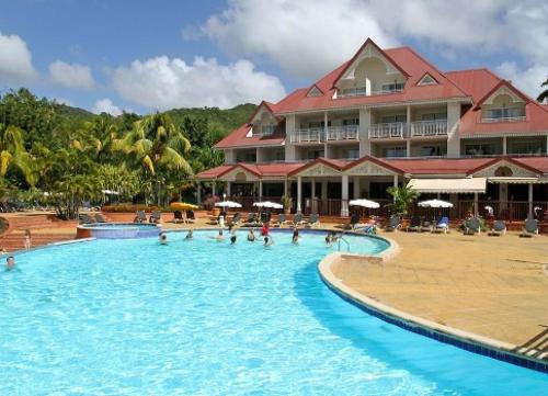 ein Resort mit einem großen Pool mit Menschen darin in der Unterkunft Studio Tropical avec vue mer dans une résidence hôtelière in Sainte-Luce