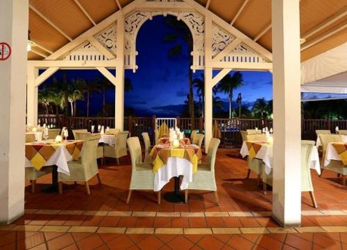 een eetkamer met tafels en stoelen in een paviljoen bij Studio Tropical avec vue mer dans une résidence hôtelière in Sainte-Luce