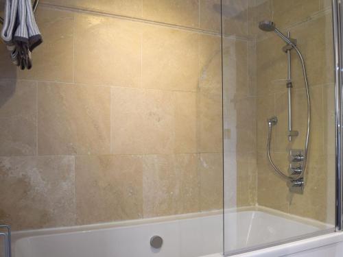 a shower in a bathroom with a glass door at The Old Stables in Swerford