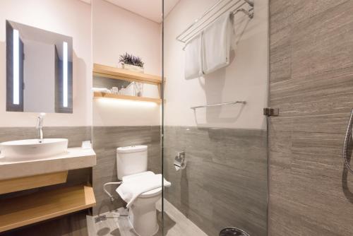 a bathroom with a toilet and a sink and a shower at Juno Tanah Abang Jakarta in Jakarta