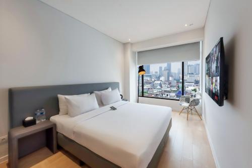 a bedroom with a large white bed and a large window at Juno Tanah Abang Jakarta in Jakarta