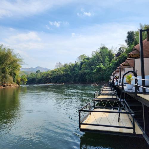 a boat on a river with people on it at VeeVaree Riverkwai Resort in Ban Kaeng Raboet