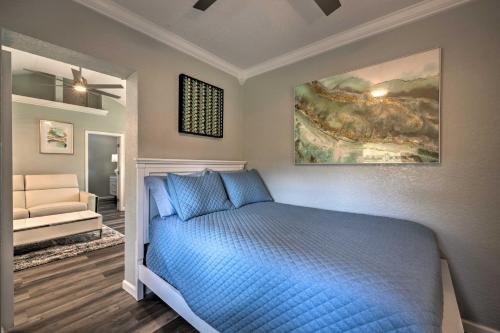 a bedroom with a blue bed and a painting on the wall at Apopka Getaway with Yard and Covered Patio in Apopka