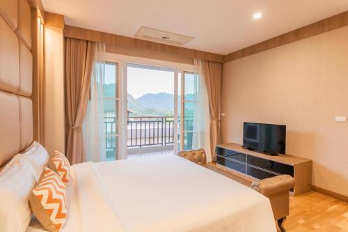 um quarto com uma cama grande e uma televisão em Hillside Residence Khaoyai em Mu Si