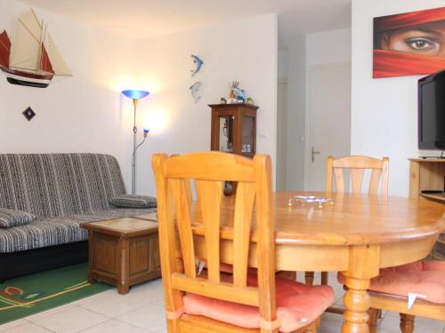 un salon avec une table en bois et un canapé dans l'établissement Maison à Saint-Georges-d'Oléron : 6 couchages, jardin clos, proche centre et plages, tout confort - FR-1-246A-172, à Saint-Georges-dʼOléron