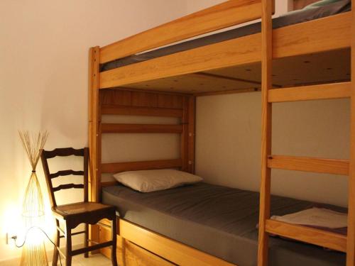 - une chambre avec 2 lits superposés et une chaise dans l'établissement Maison à Saint-Georges-d'Oléron : 6 couchages, jardin clos, proche centre et plages, tout confort - FR-1-246A-172, à Saint-Georges-dʼOléron