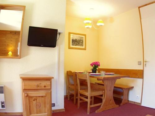 ein Esszimmer mit einem Tisch und einem TV an der Wand in der Unterkunft Appartement Valmorel, 2 pièces, 5 personnes - FR-1-291-886 in Valmorel