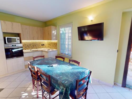 une cuisine avec une table et des chaises ainsi qu'une télévision dans l'établissement Charmant 3P au calme avec terrasse, proche de la mer à Menton - FR-1-196-317, à Menton
