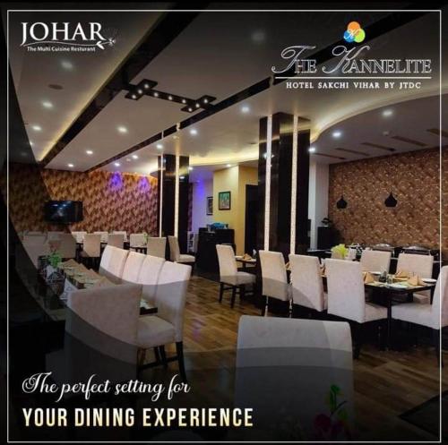 a restaurant with white chairs and tables and a sign at The Kannelite in Jamshedpur