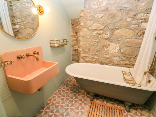 a bathroom with a bath tub and a sink at Barn Cottage in Saint Erth