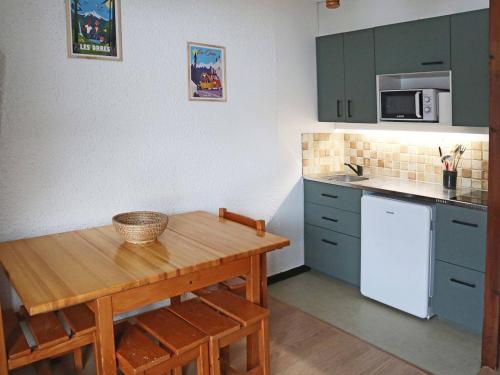 Il comprend une petite cuisine avec une table en bois et un réfrigérateur blanc. dans l'établissement Studio confortable au pied des pistes avec balcon sud-ouest - FR-1-322-513, aux Orres