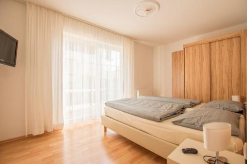 ein Schlafzimmer mit einem Bett und einem großen Fenster in der Unterkunft Ferienwohnung Ramsee in Herrsching am Ammersee