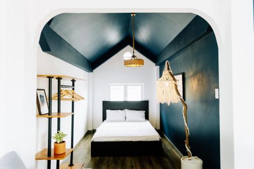 1 dormitorio con 1 cama y techo azul en The Beachhouse Villa- Biệt Thự 4 Phòng Bãi Sau- 4 bedrooms Villa- 5' to Bai Sau Beach, en Xã Thang Tam