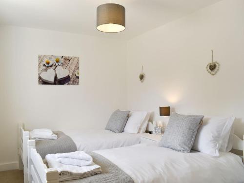 Duas camas num quarto com paredes brancas em Cherry Cottage - Ukc3990 em South Perrott