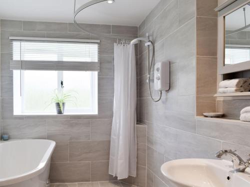 uma casa de banho com um chuveiro e um lavatório. em Cherry Cottage - Ukc3990 em South Perrott