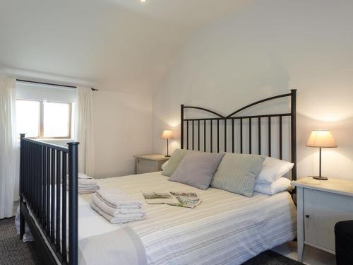 a bedroom with a large bed with a black frame at Hogsnorting Villa in Blythburgh