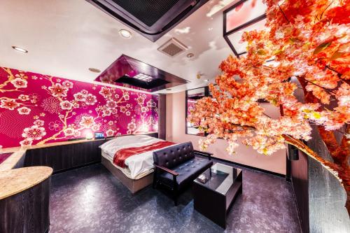 Un dormitorio con una pared rosa con un árbol en Hotel Lotus Higashiosaka -Adult Only, en Osaka