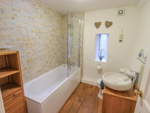 uma casa de banho com uma banheira, um WC e um lavatório. em Lady Barn em Grange Over Sands