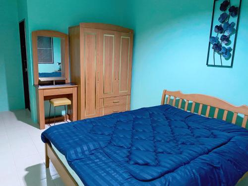 una camera con letto blu e armadio in legno di Nature home a Ban Laem Hin